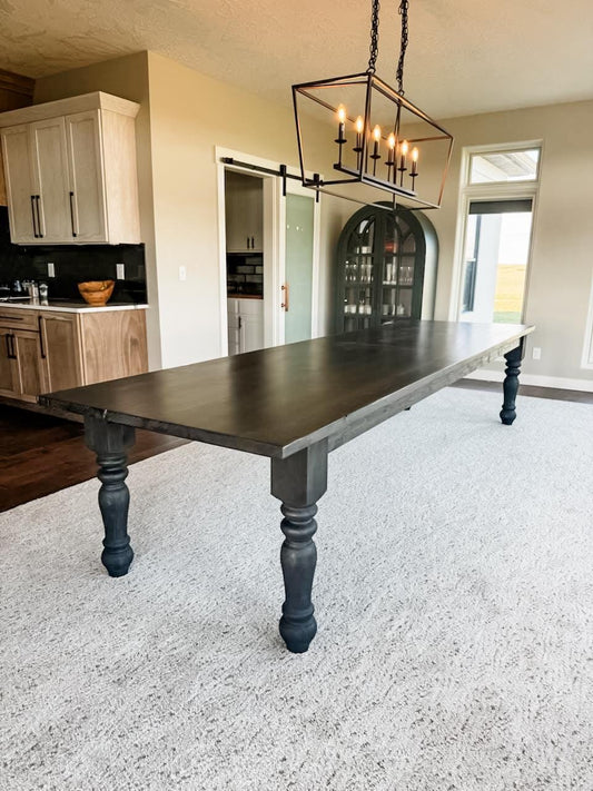 Black farmhouse dining table with thick legs and smooth rectangular top