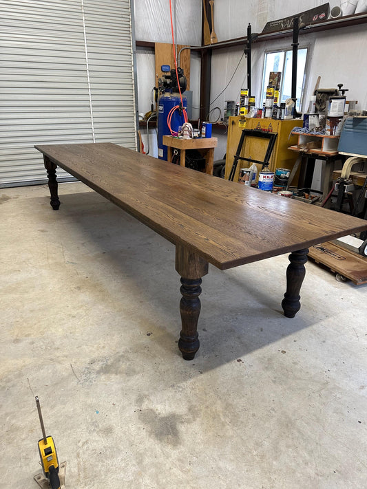 Solid wood dining table with turned legs and wide rectangular top in dark brown