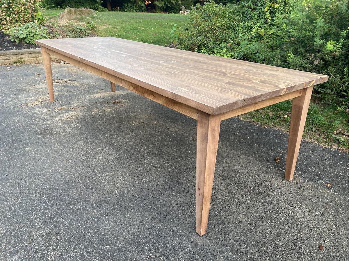 Rectangular solid wood dining table with tapered legs and light wood tabletop