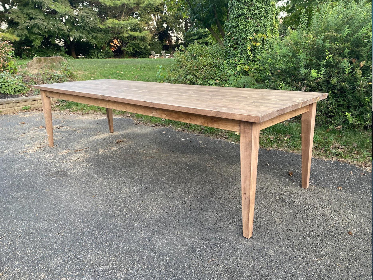 Solid wood dining table with tapered legs and pale tabletop, rectangular top